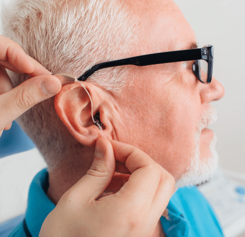 a Naples, FL man trying on hearing aids at an audiology center