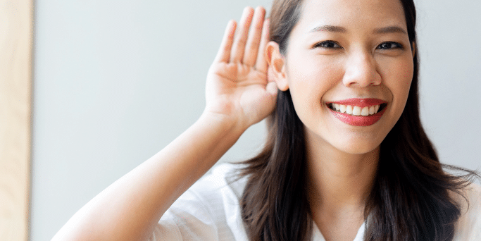 Woman smiling with her hand to her ear